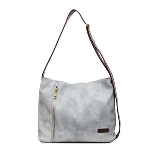 Minimalist light grey canvas tote bag with brown leather straps and metal zipper detail