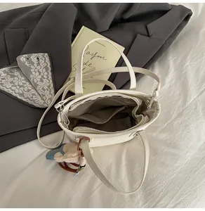 Vue détaillée de l'intérieur du sac crème montrant les poches zippées et la doublure