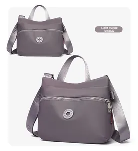 Detail view of light purple nylon crossbody bag with durable zippers and logo