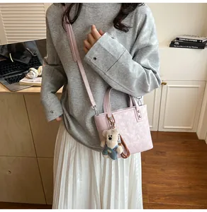 Détail du sac à main en simili cuir rose avec breloque ours et bandoulière