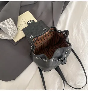 Vue détaillée du sac seau noir avec doublure rayée et détails en chaîne argentée