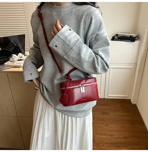 Détail du sac carré en cuir verni rouge avec doubles fermetures éclair et bandoulière