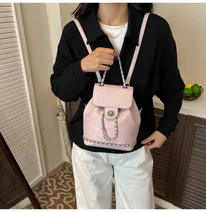 Vue détaillée du sac à dos en cuir rose avec chaîne argentée et fermoir rotatif en métal