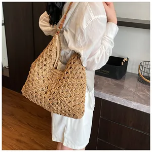 Detail of bohemian woven tote bag with brown leather strap and intricate hollow patterns
