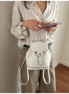 Détail du sac à dos en cuir PU blanc avec chaînes argentées et fermoir pivotant