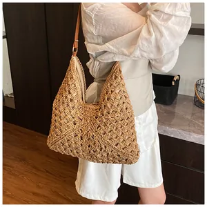 Detail of bohemian hollow straw tote bag with brown leather strap and fabric lining