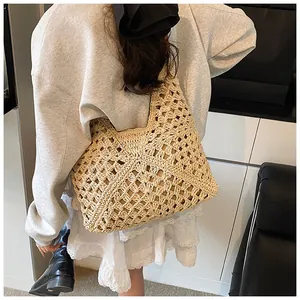 Detail of hand-woven straw tote bag showing beige crochet texture and diamond pattern