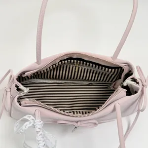 Pink faux leather shoulder bag with chic bow details and white lace pendant decoration