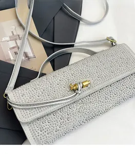 Détail d'un sac de soirée en strass argenté avec un fermoir en métal à nœud unique