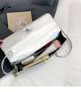 Intérieur spacieux du sac argenté montrant le rangement pour téléphone et cosmétiques