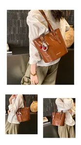Macro detail of brown patent leather tote with pleated texture and cherry charm