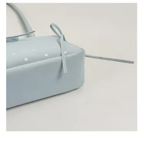 Detailed close-up showing the reinforced bottom and stitching of the blue polka dot bag
