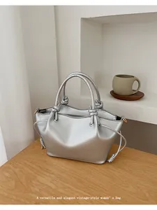Detailed view of silver vintage tote with elegant knot handles and drawstring texture