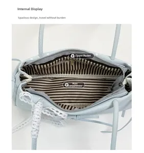 Internal display of the light blue handbag featuring striped lining and a secure zipper pocket