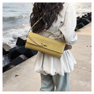 Détail du sac baguette jaune à strass avec bandoulière dorée et fermoir pivotant