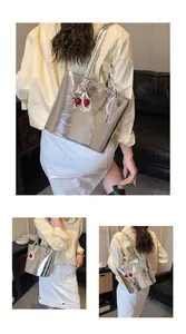 Detailed views of silver metallic tote bag with pleated texture and cherry charm