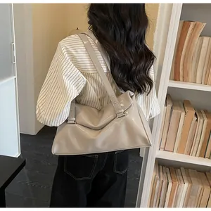 Detail of glossy cream tote bag showing smooth leather texture and wide shoulder straps