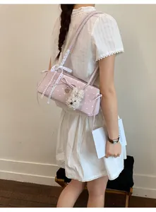 Pink polka dot shoulder bag with lace bow, bunny pendant and floral print details