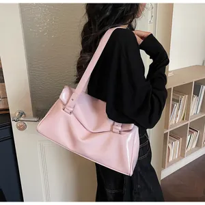 Close-up of pink patent leather tote bag showing glossy texture and silver buckle details