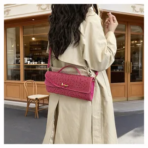 Détail du sac à main fuchsia en strass avec boucle dorée et bandoulière chic