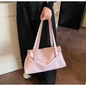 Close-up of light pink glossy patent leather tote bag with silver rivets and flap closure