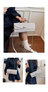 Vue détaillée d'un sac à main argenté en strass avec fermoir nœud doré et bandoulière