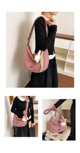 Detail of red and white checkered hobo bag with cute plush rabbit charm and wide strap