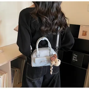 Détail du mini sac bleu clair avec nœud décoratif et pendentif ours mignon