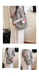 Close-up of a large black and white checkered crescent tote bag with a plush rabbit charm