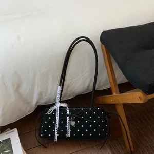 Detailed shot of black polka dot handbag with lace bow and heart-shaped pendant