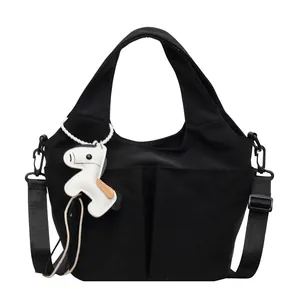 Sac à main minimaliste en toile noire avec plusieurs poches et pendentif cheval