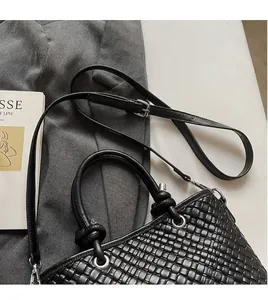 Dettaglio della trama intrecciata nera della borsa a secchiello con finiture in argento