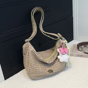 Green and purple checkered hobo shoulder bag with plush bear charm and tassel