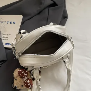 Sac polochon blanc minimaliste en similicuir avec fermeture éclair et breloque ours
