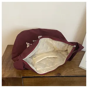 Detailansicht der großen weinroten Tasche mit Steppfutter und Reißverschluss-Innentasche