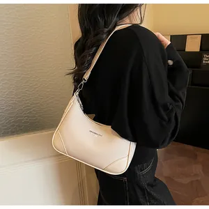 French style large beige crescent shoulder bag with lychee texture shown on a model