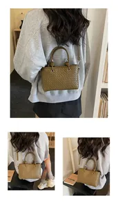 Dettaglio borsa tote in pelle intrecciata verde oliva con manico cilindrico e tracolla