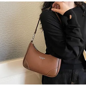 Detail of retro brown leather hobo bag with white MIKAXIQI & BAG brand logo printing
