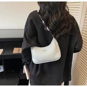 Detail of light grey hobo bag with pebble leather texture and gold logo lettering