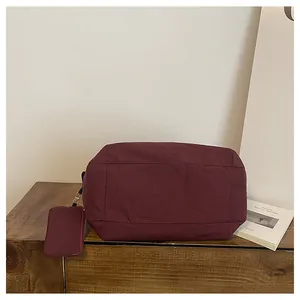 Details einer burgunderroten Nylon-Umhängetasche mit passender abnehmbarer kleiner Münztasche