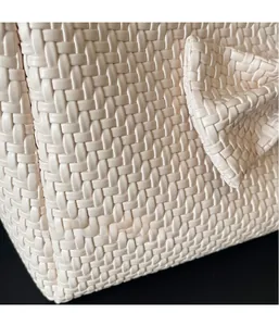 Detailed close-up of woven texture and ribbon bow on beige large capacity tote bag