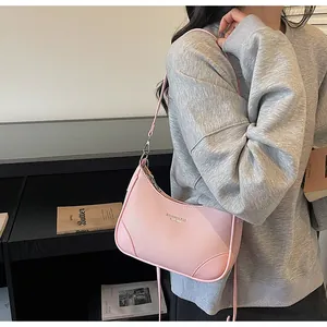 Side view of pink leather crescent underarm bag with silver hardware on model