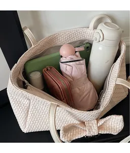 Detail view of woven tote bag interior showing large capacity for umbrella and tablet