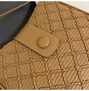 Détail d'un sac seau marron montrant la texture matelassée et le fermoir magnétique