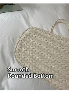 Vista dettagliata della trama intrecciata beige e della base rotonda della borsa