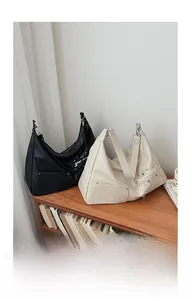 Detailed comparison of large black and beige hobo bags with metallic rivets and zippers