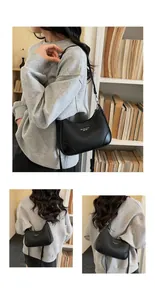 Detail showing black lychee leather crescent bag with adjustable strap and silver metal buckle