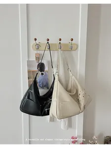 Detail view of vintage-style black and cream leather bags with silver stud accents