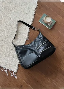 Detail shot of black leather biker tote bag with silver zippers and metal studs