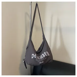 Detailansicht der großen dunkelgrauen Nylon-Umhängetasche mit Druck und kleiner Tasche